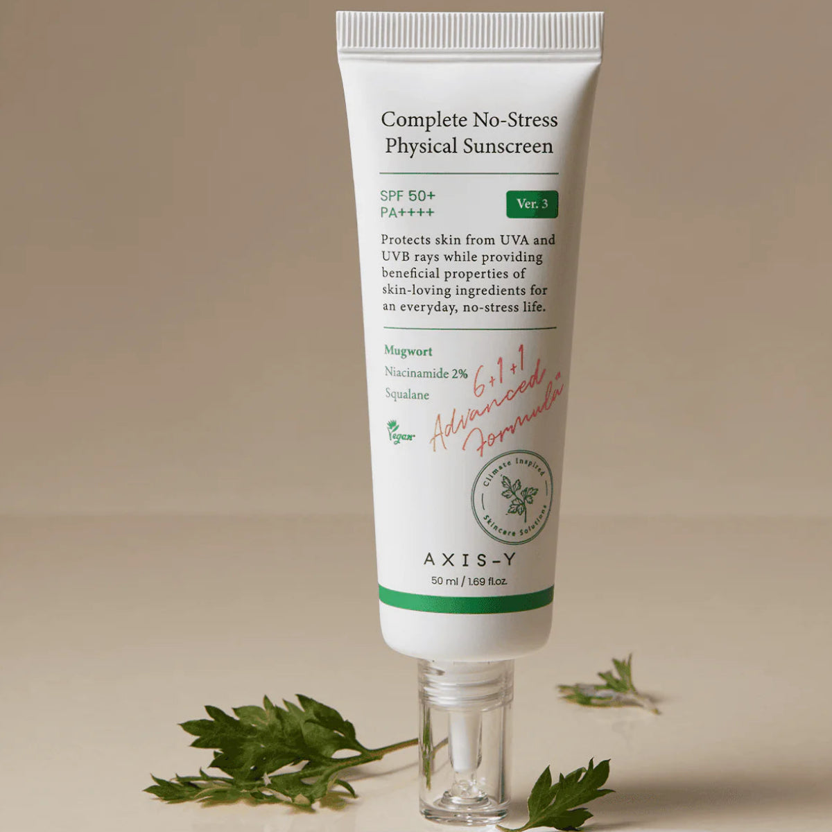 Tube of AXIS-Y Complete No-Stress Physical Sunscreen on a beige background with leaves around.