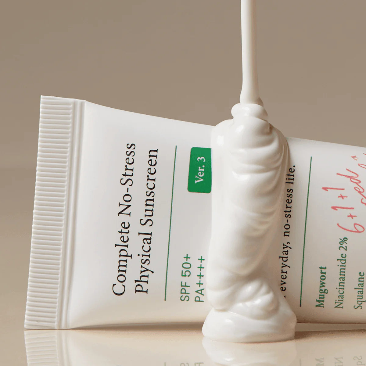 Tube of 'Complete No-Stress Physical Sunscreen' with a white applicator on a reflective surface.