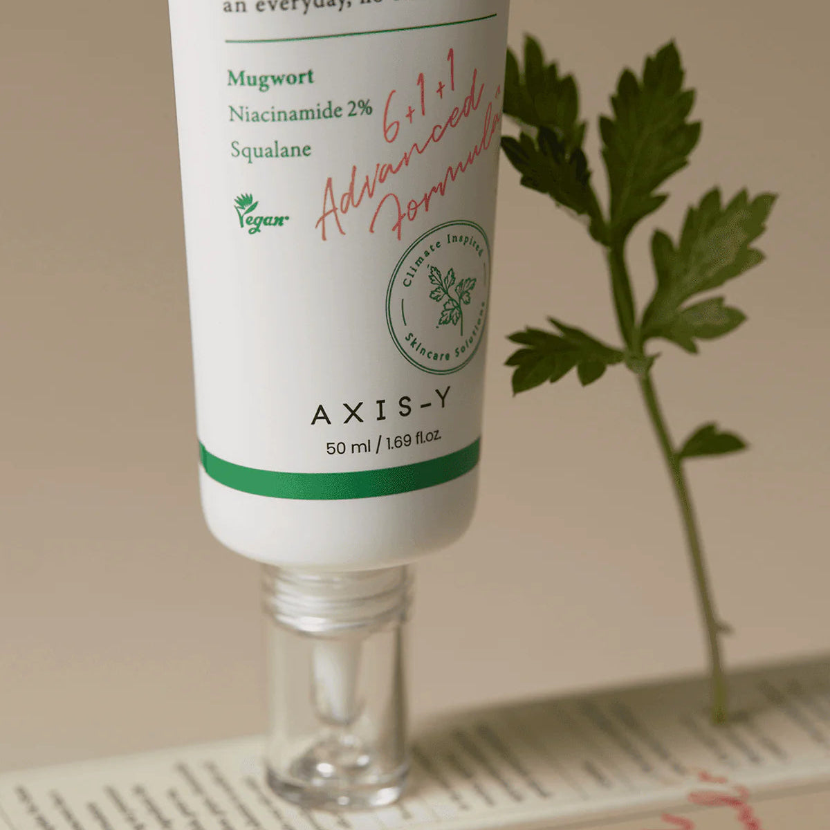 Axis-Y skincare product with mugwort and niacinamide on a beige background