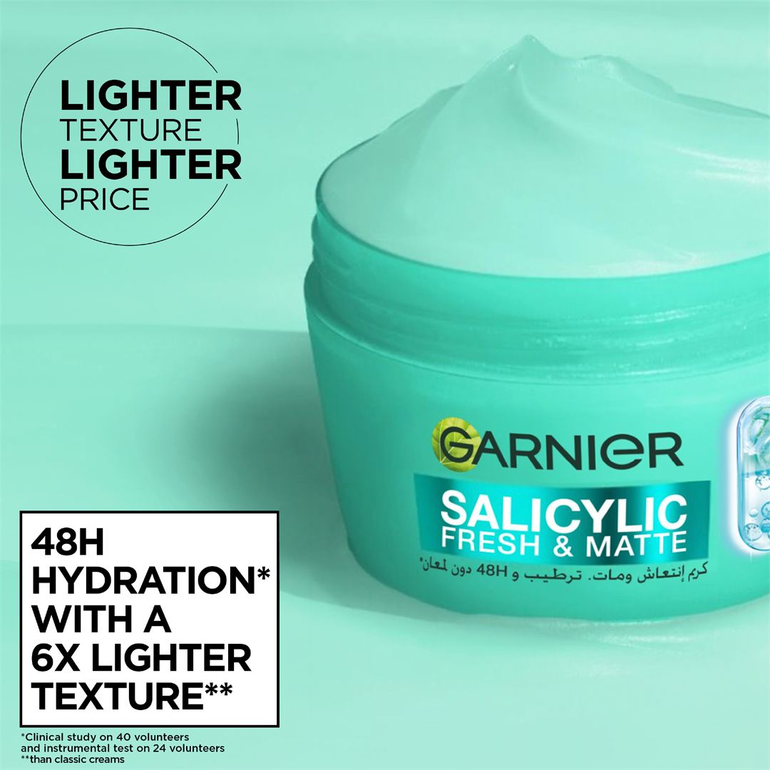 Garnier Salicylic Fresh & Matte face cream in a mint green jar with white cream visible at the top, set against a matching mint green background with promotional text overlays.