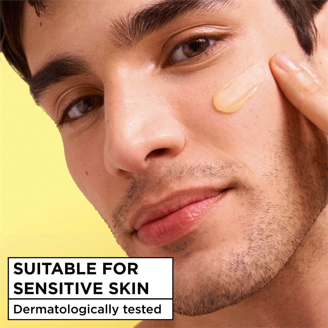 Close-up of a man applying or touching his cheek with a smear of cream product, with text reading 'SUITABLE FOR SENSITIVE SKIN' and 'Dermatologically tested' on a yellow background.